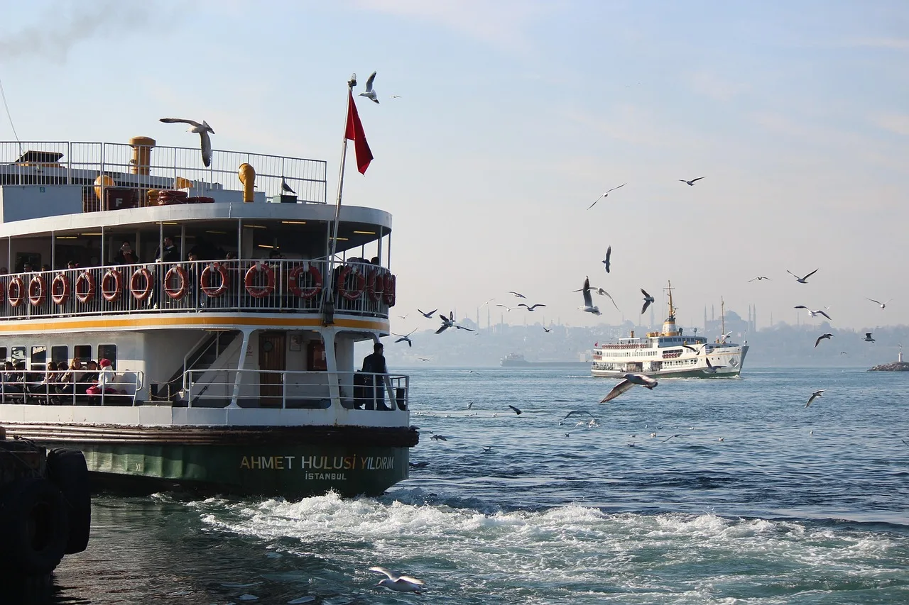 Passengers standing and seated on the open deck of a crowded Chao Phraya commuter boat