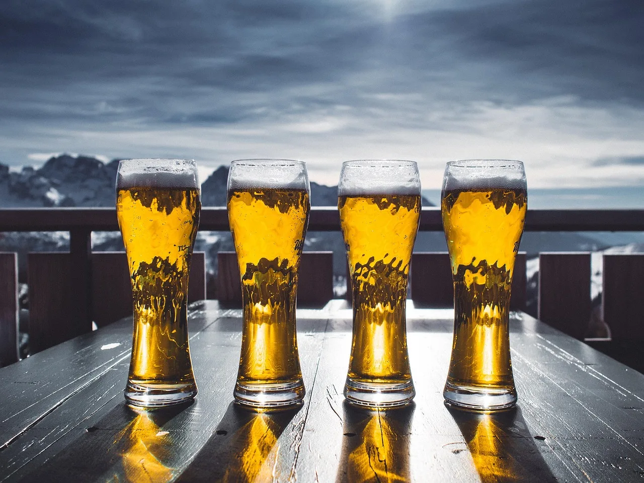 Three sizes of beer glass on a bar counter: a lined pint, a half and a two-thirds schooner