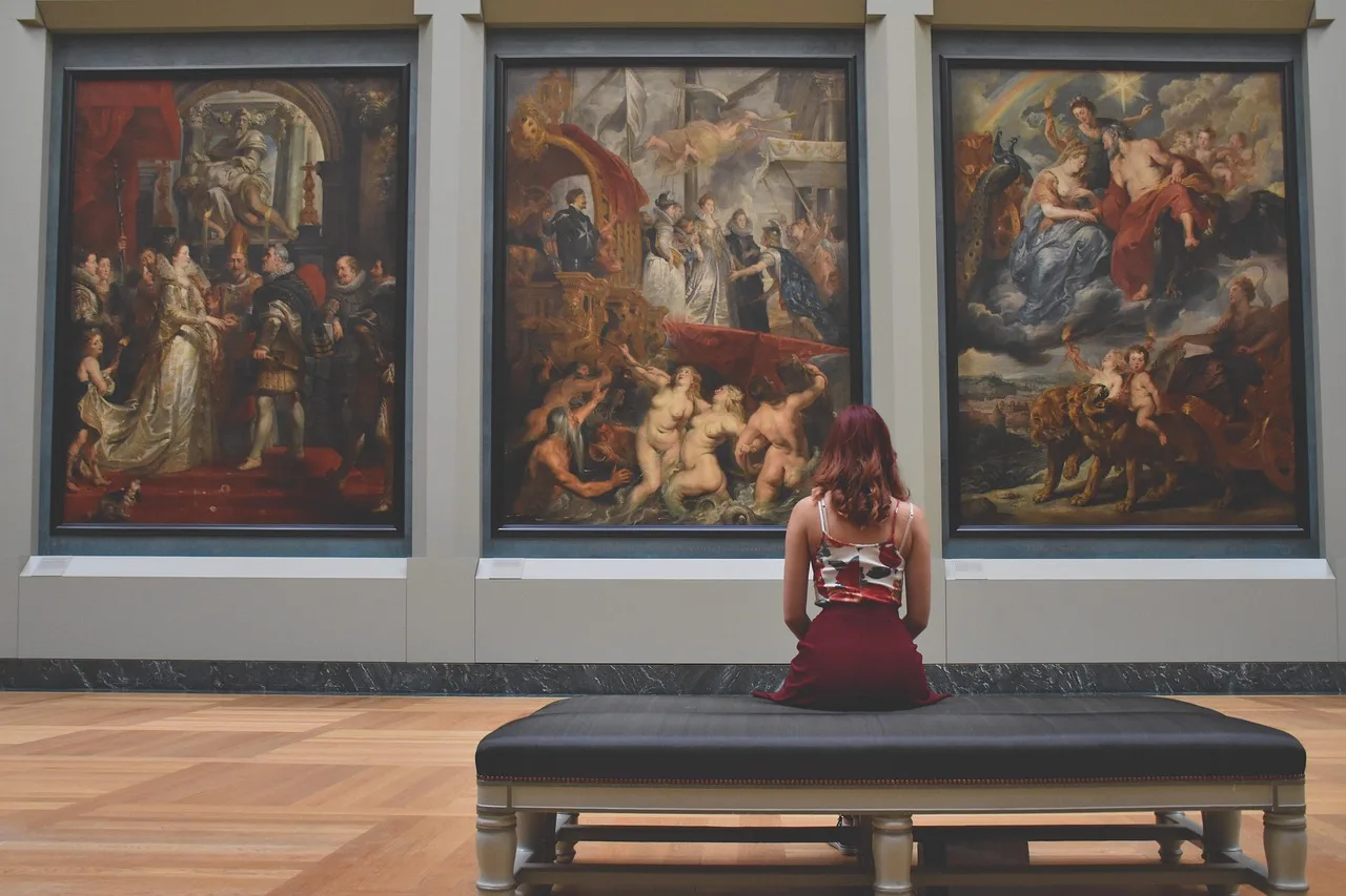 An empty bench in the centre of a quiet museum gallery, blurred paintings on the walls behind