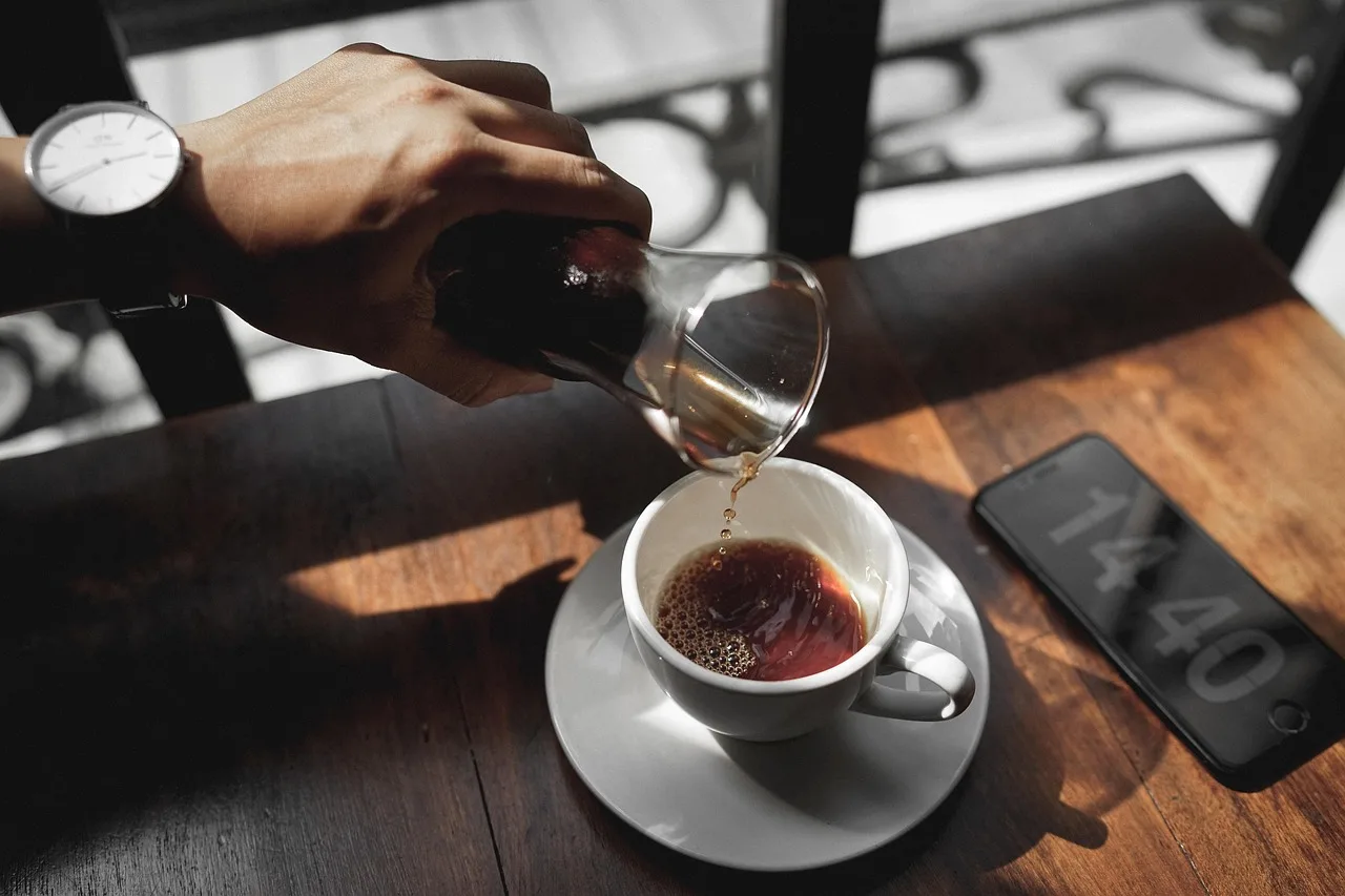 Coffee, a folded paper map and keys on a café table on a quiet morning street