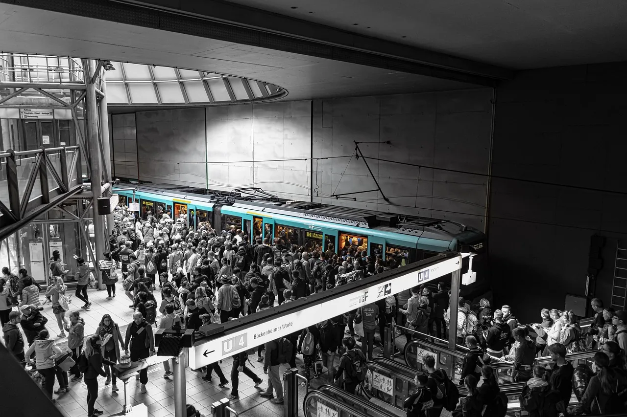 Passengers crowded around the open doors of a train on a busy Paris Metro platform