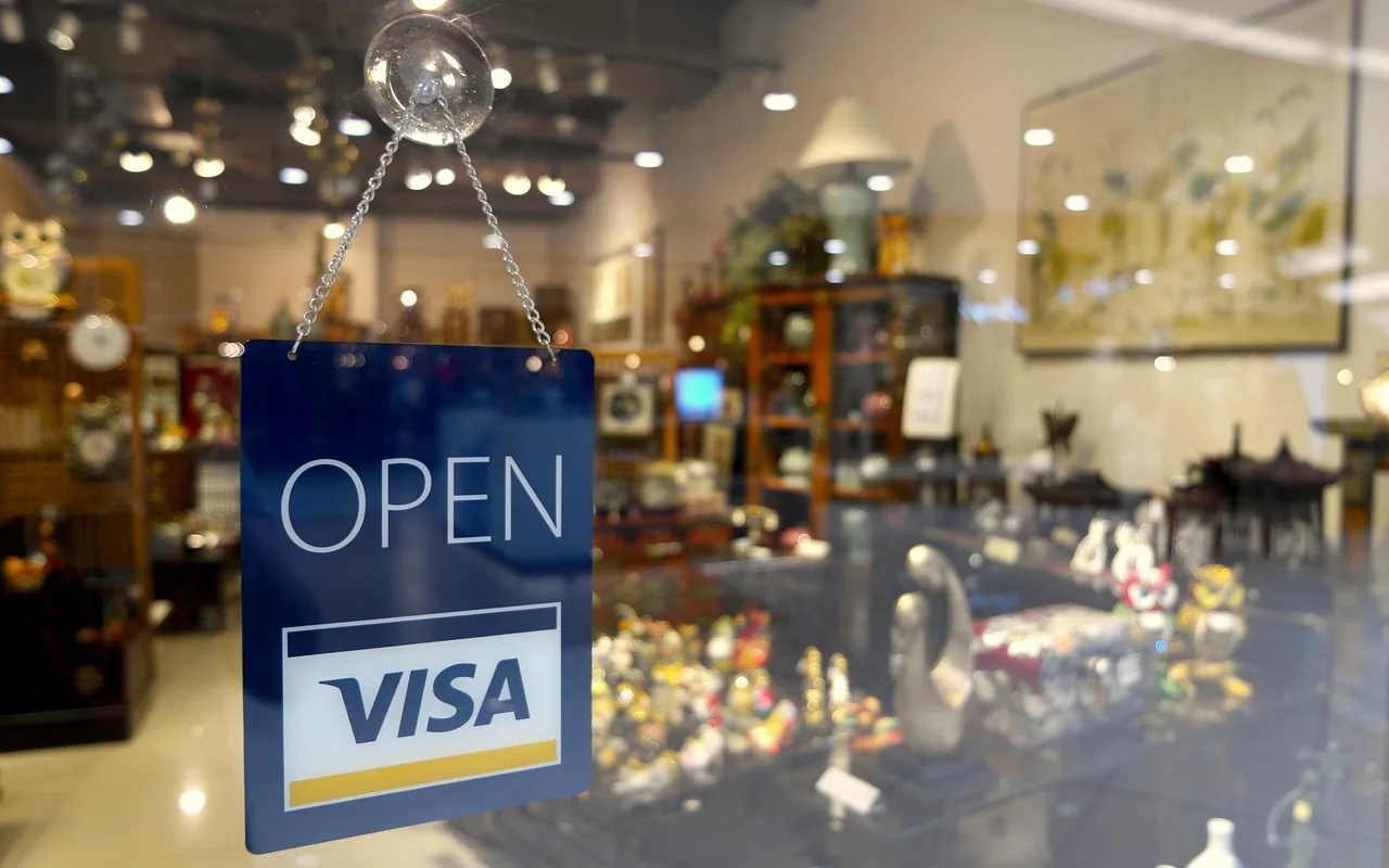 A handwritten card-only sign taped inside a shop window