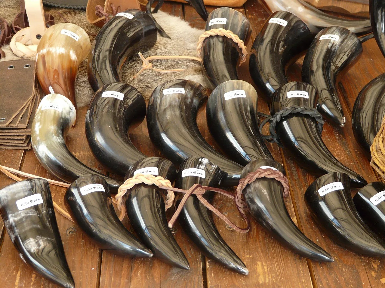 A Georgian drinking horn lying on its side on a tablecloth next to bread and herbs