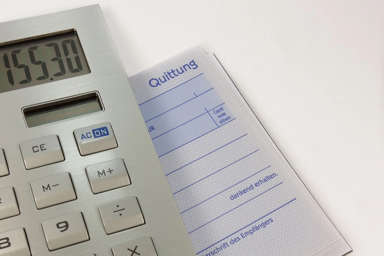 An American shop receipt on a counter showing a subtotal, a separate sales tax line and the total