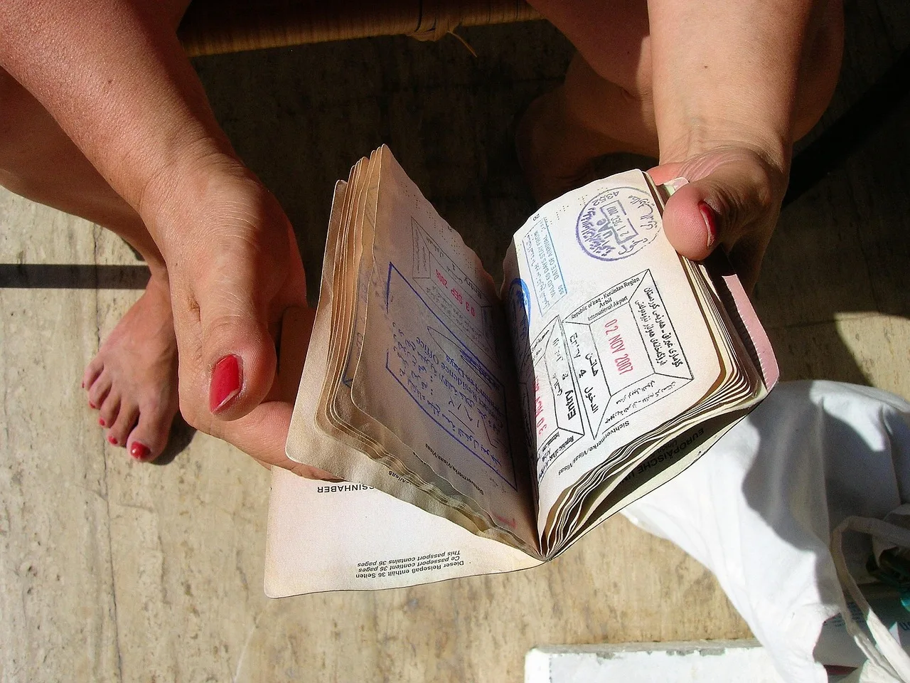 A handwritten index card of account details tucked into a rucksack pocket beside a passport