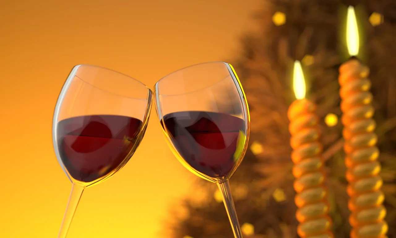 Three raised glasses of beer, clear spirit and wine over a wooden pub table, hands only