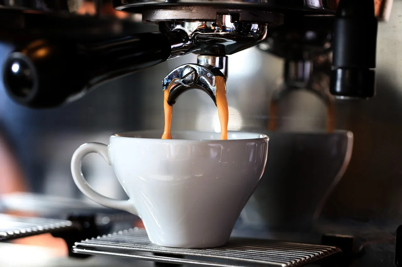 People standing at a crowded Italian bar counter while a barista works a chrome espresso machine
