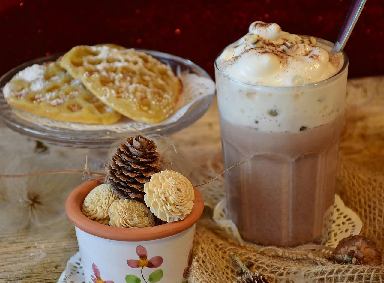 A marocchino in a small clear glass showing layers of cocoa, coffee and milk foam