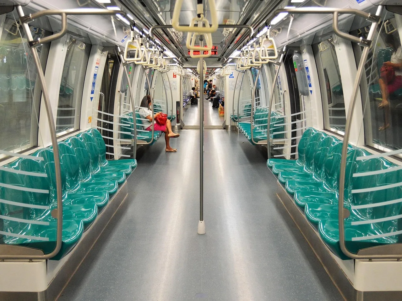 A crowded Seoul subway car with one pink priority seat left empty at the end of the bench
