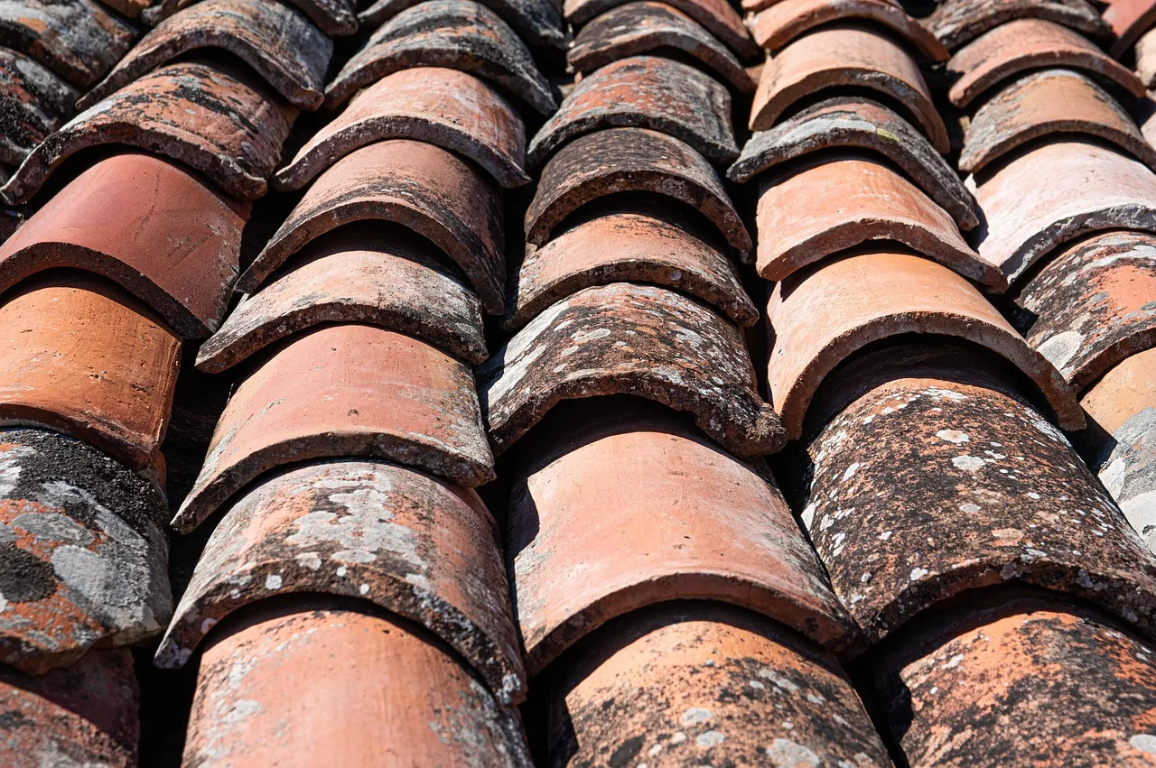 An Edo-period wall of alternating clay and roof-tile layers with a tiled cap, along a narrow Yanaka lane