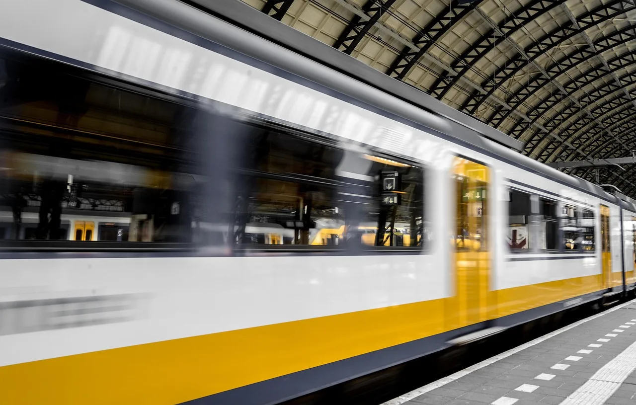A yellow Italian ticket validating machine on a station platform with a ticket slot and card reader