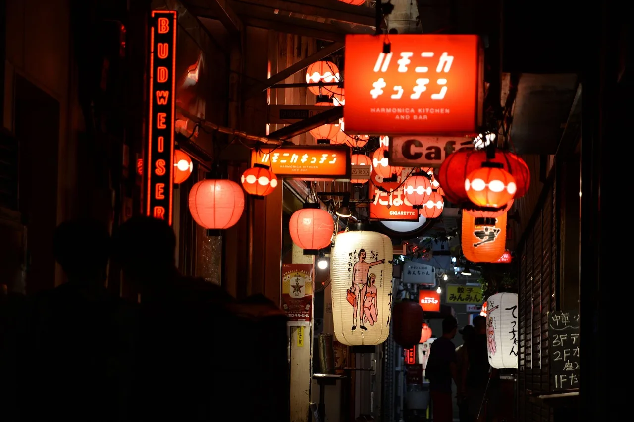 A small Japanese counter restaurant busy in the early evening, dusk through the open doorway