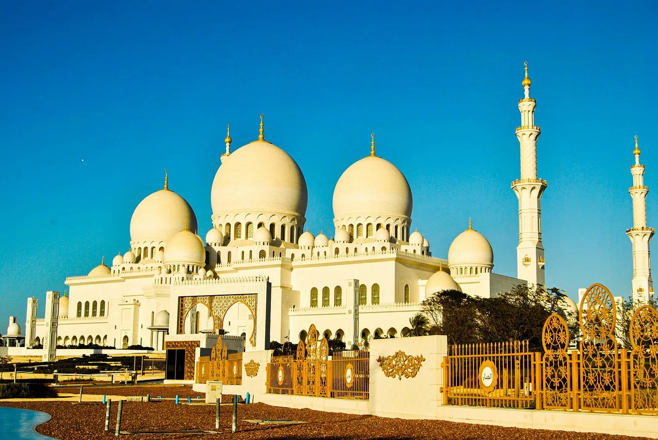 The Jumeirah Mosque in Dubai, its two minarets and dome lit by late afternoon sun